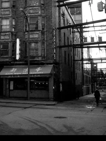 Vancouver street at night. Rooms sign, alley wires, the city not the postcard.
